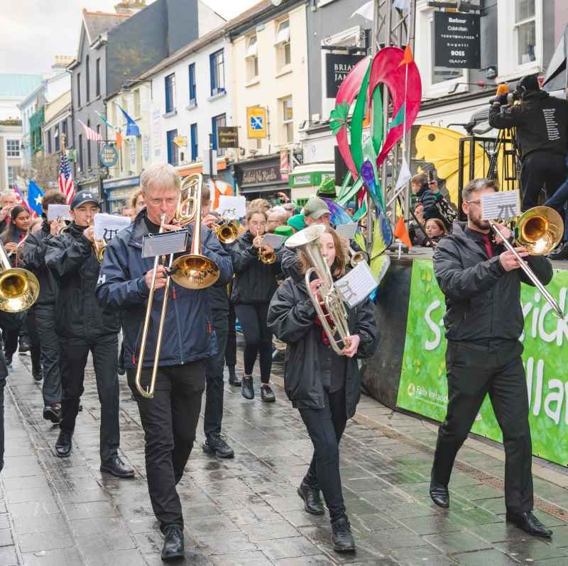 group of people walking in parade playing instruments