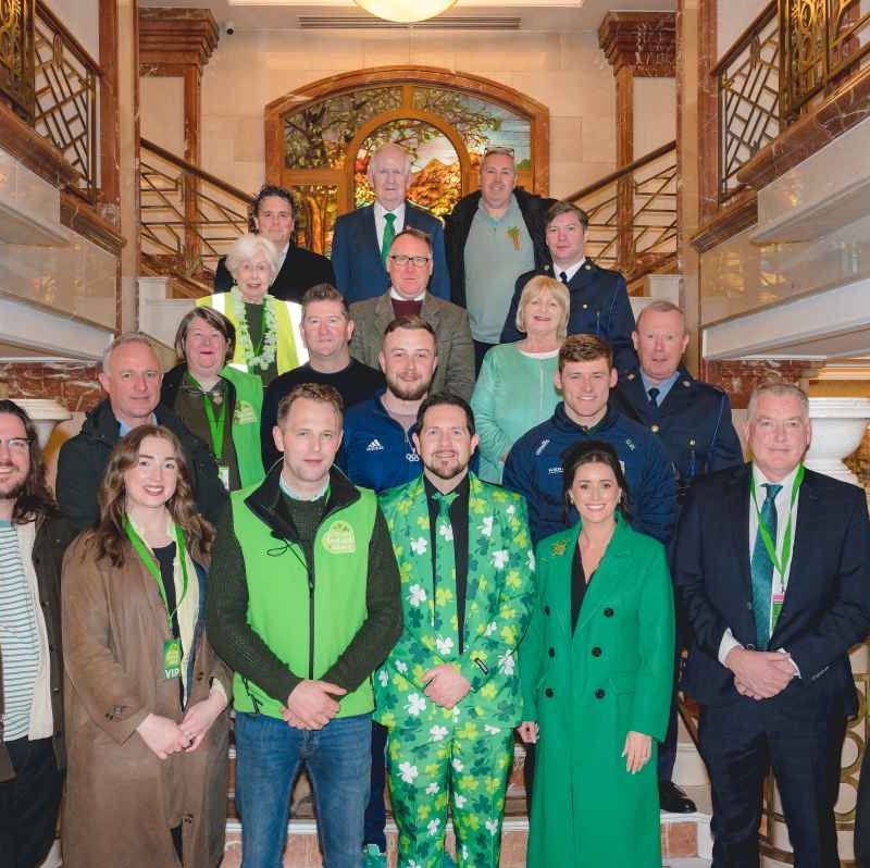 Group shot of people indoors in hotel wearing St. Patrick's Day attire